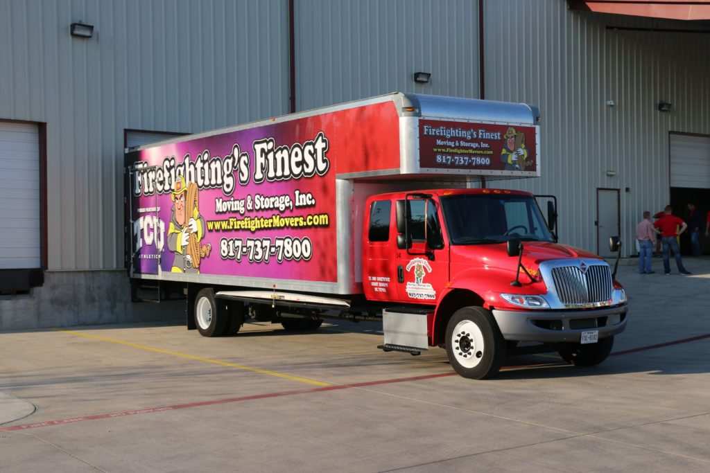 Truck of Firefighting's Finest Moving & Storage parked near a warehouse in Hutto, TX